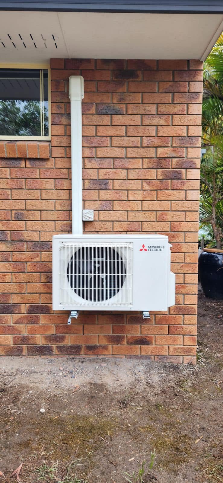 Mitsubishi Electric split system outdoor unit installed on a brick wall